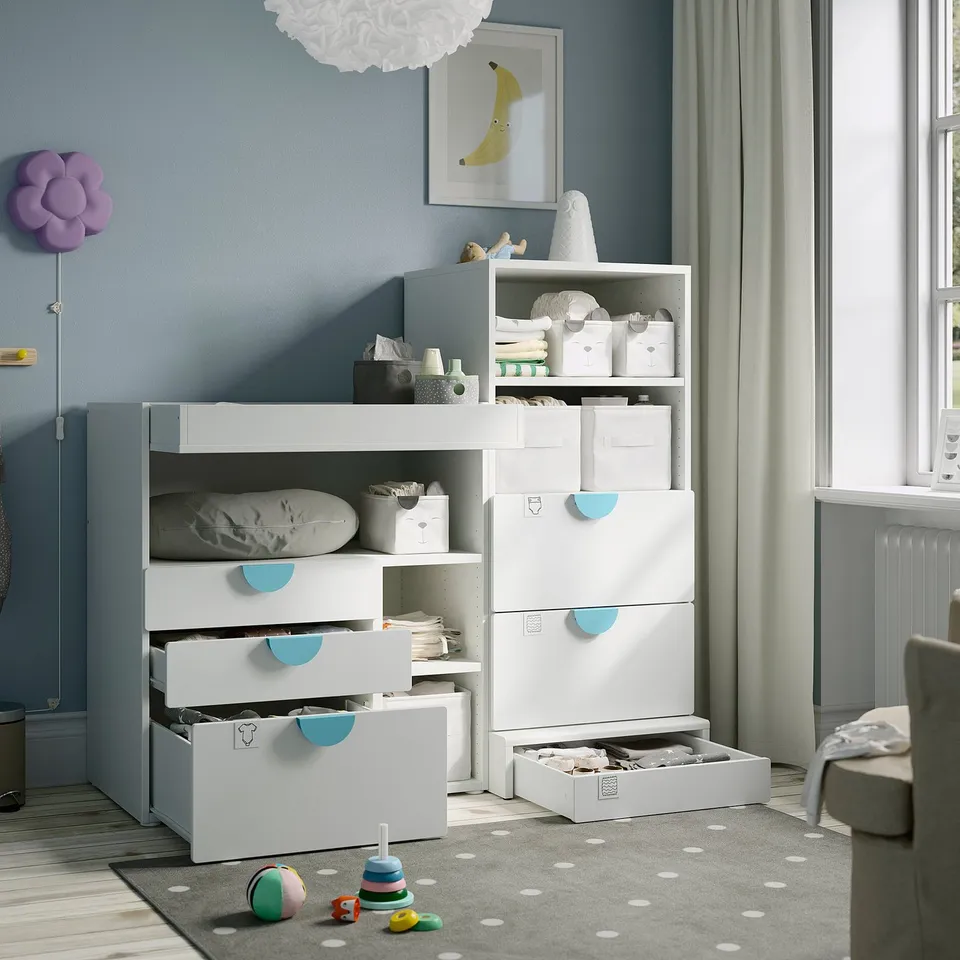 Kids room with grey dotted rug, safe & non-slip. Blue-handled storage & cosy lamp, light blue curtains.