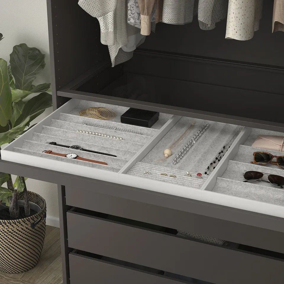 Jewellery organiser tray with compartments for necklaces, rings, and watches in opened drawer.