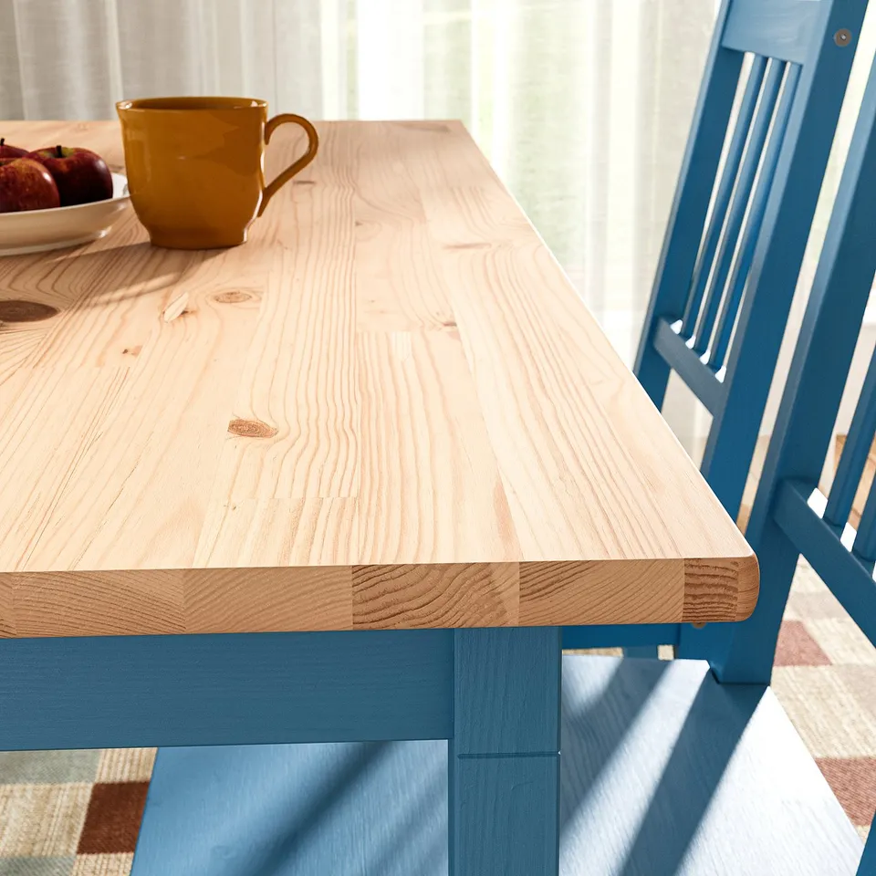 Wooden table with smooth, natural finish and sturdy blue chair.