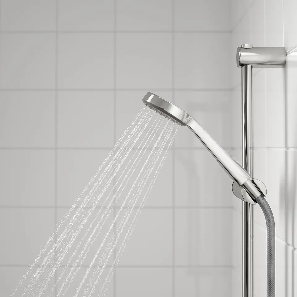 A modern shower setup with a riser rail and hand shower in use, displaying a wide, full spray.