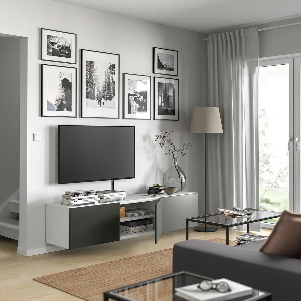 Modern living room with BESTÅ tv bench, flat screen, photos, floor lamp, and coffee table.