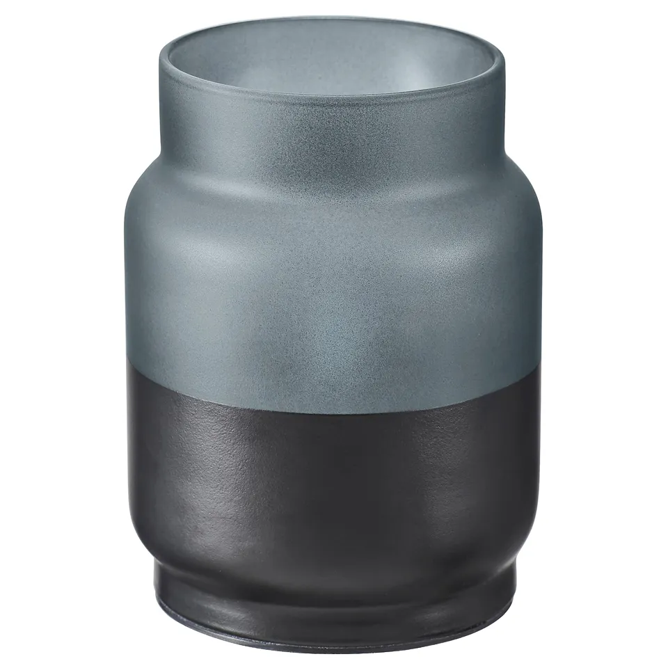 A modern, two-toned jar-shaped vase in green and black. Its a stylish home decor piece made from glass.