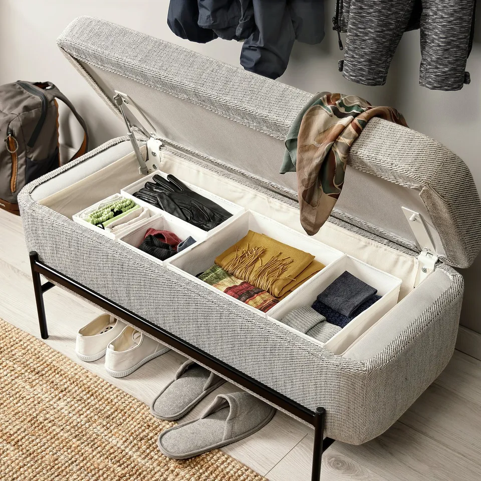 Open storage bench showing organised compartments with accessories inside.