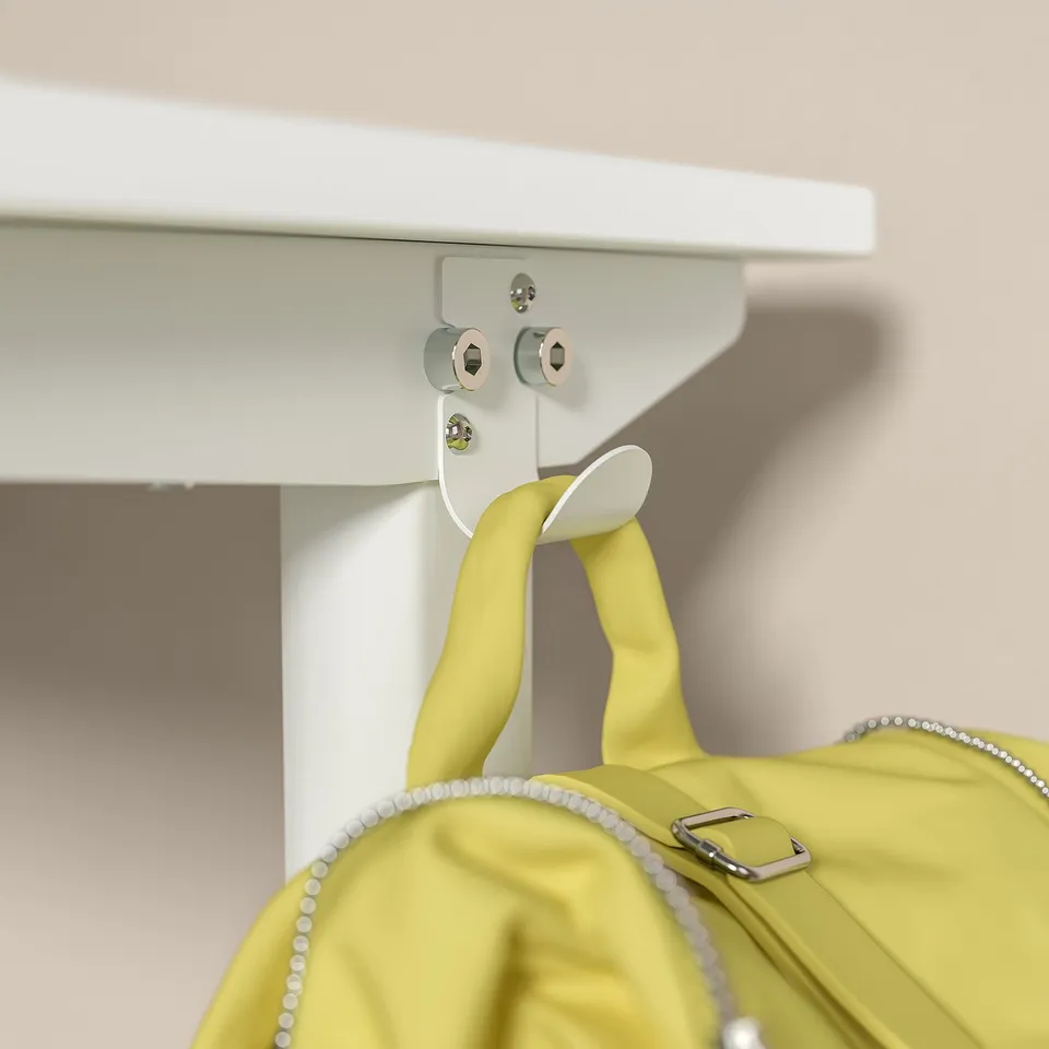 A bright yellow bag hangs from a desk, secured by hooks. The desk modern, white, adjustable legs with steel and plastic components.