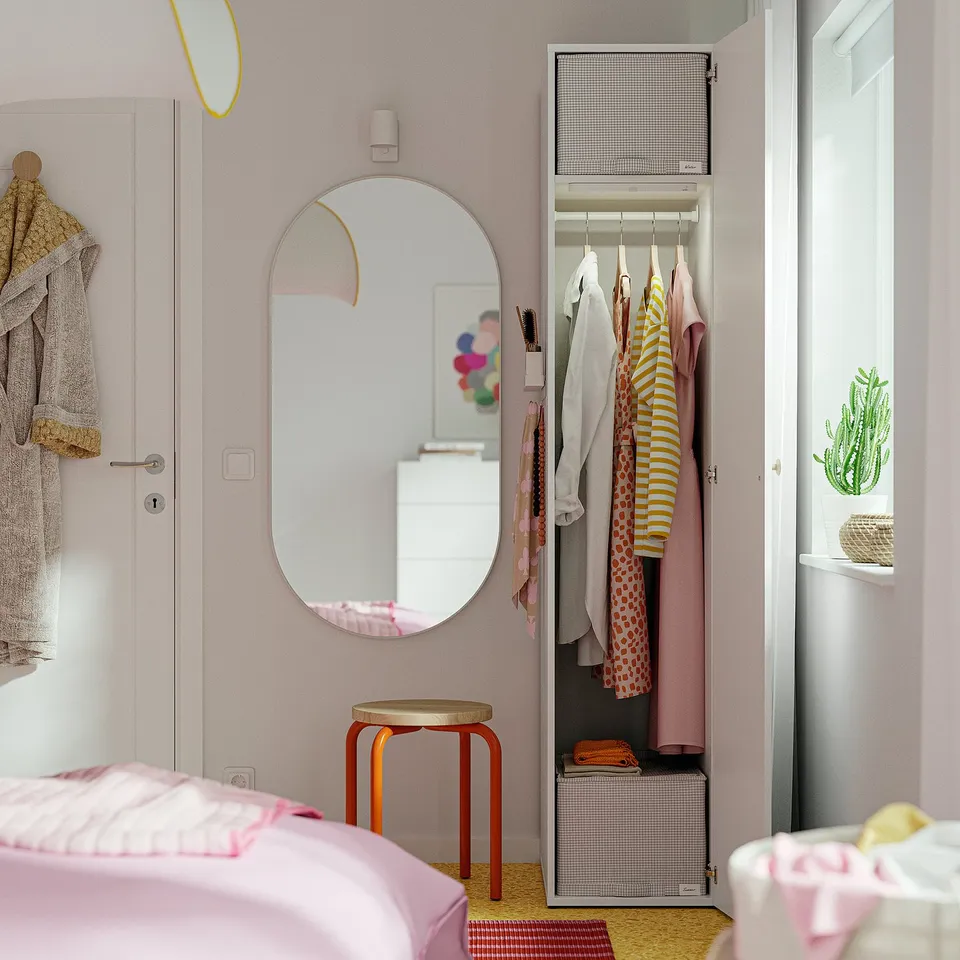 Open closet in bedroom showing clothes and storage. Mirror and stool visible.