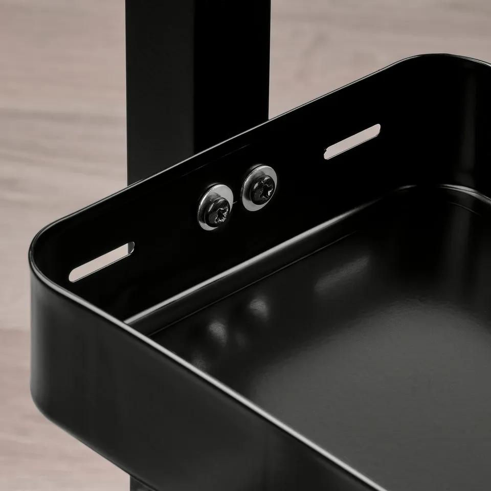 Black metal shelf with visible screws and modern design, mounted on a wooden surface.