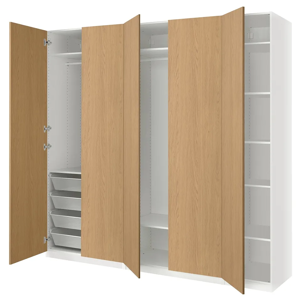A light brown and white ikea PAX wardrobe with open doors revealing shelves and drawers.