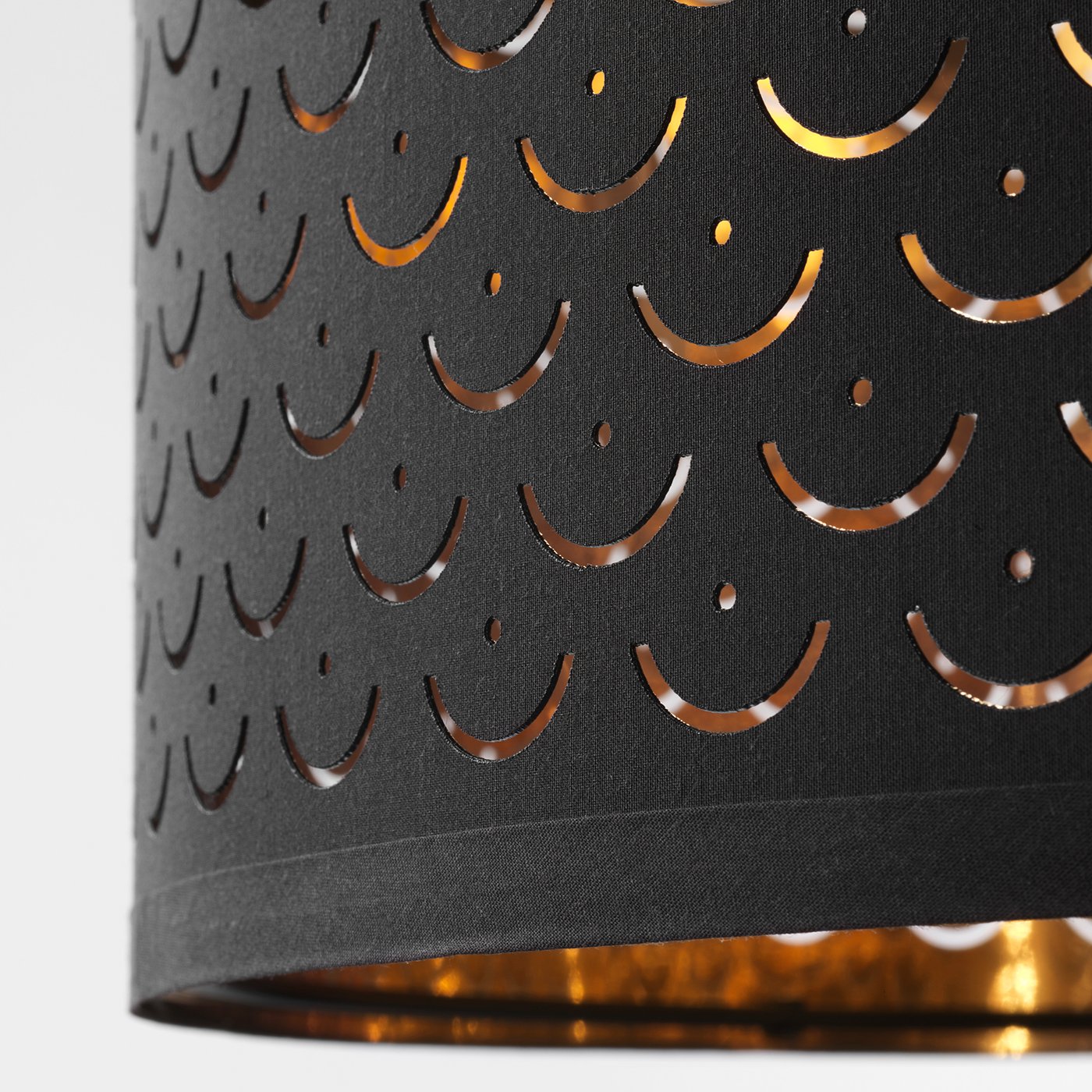 Black modern lamp shade with intricate cut-out patterns casts elegant light.