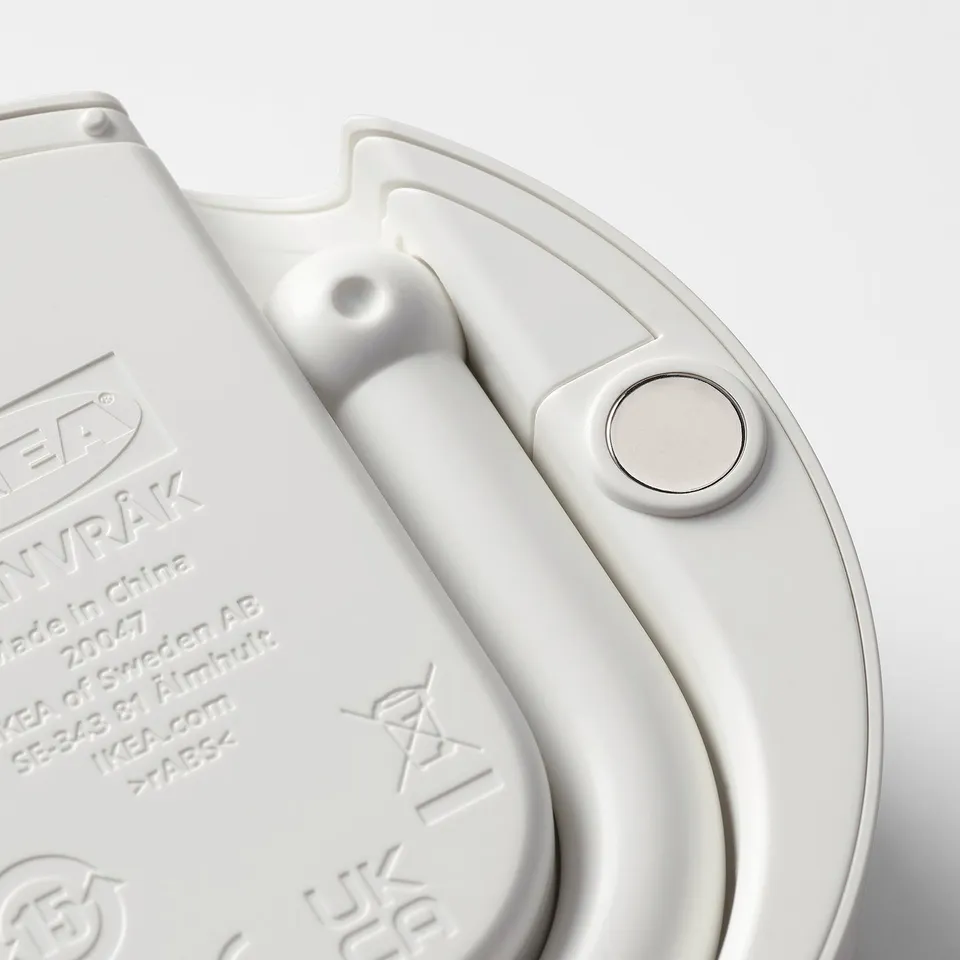 Close-up of a sleek white digital clock with a magnetic back and a simple, modern design.