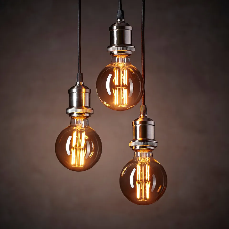 Three warm, glowing vintage-style led bulbs hang from metal fixtures, emitting a soft, inviting light.