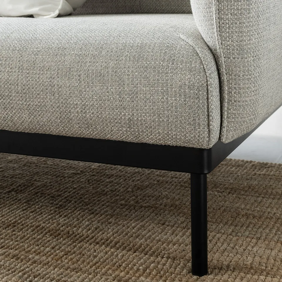 Modern grey upholstered sofa with black metal legs.