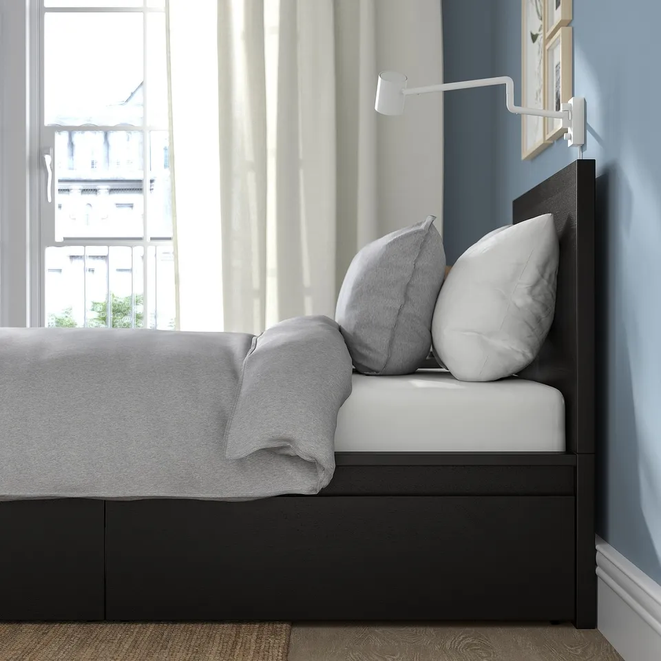 Black MALM bed, open drawer, grey bedding, blue wall, city view.