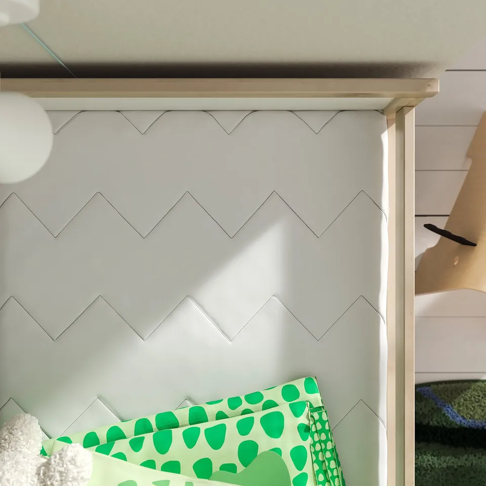 Kids room with zigzag wall, green pillow, wooden bed, safe mattress.