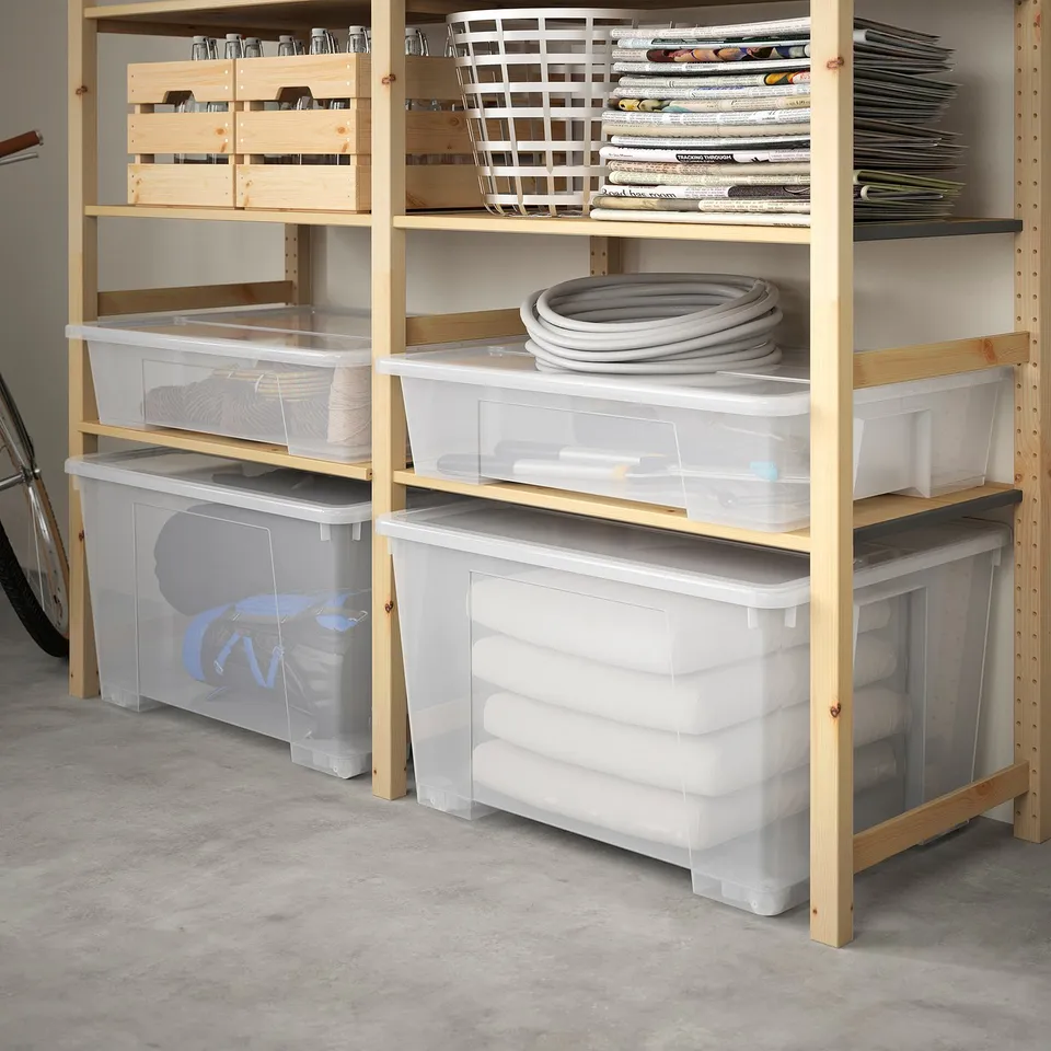 Wooden shelves with clear plastic storage boxes, some holding rolled items, stacked neatly.