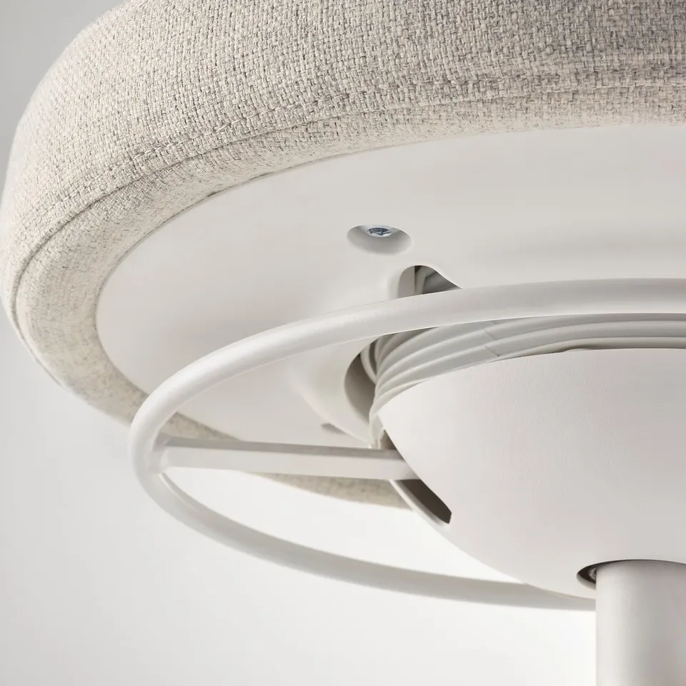 Close-up of a modern office chairs underside, showing sleek white metal frame and smooth mechanism, highlighting its quality and design.