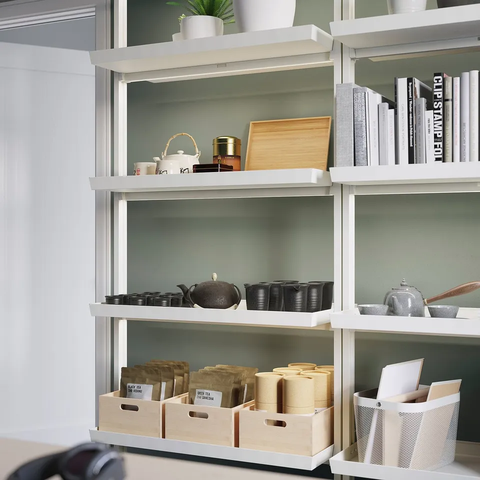 White MITTZON shelving unit with various items. Includes stacks of boxes, teapots, cups, and books on four shelves.