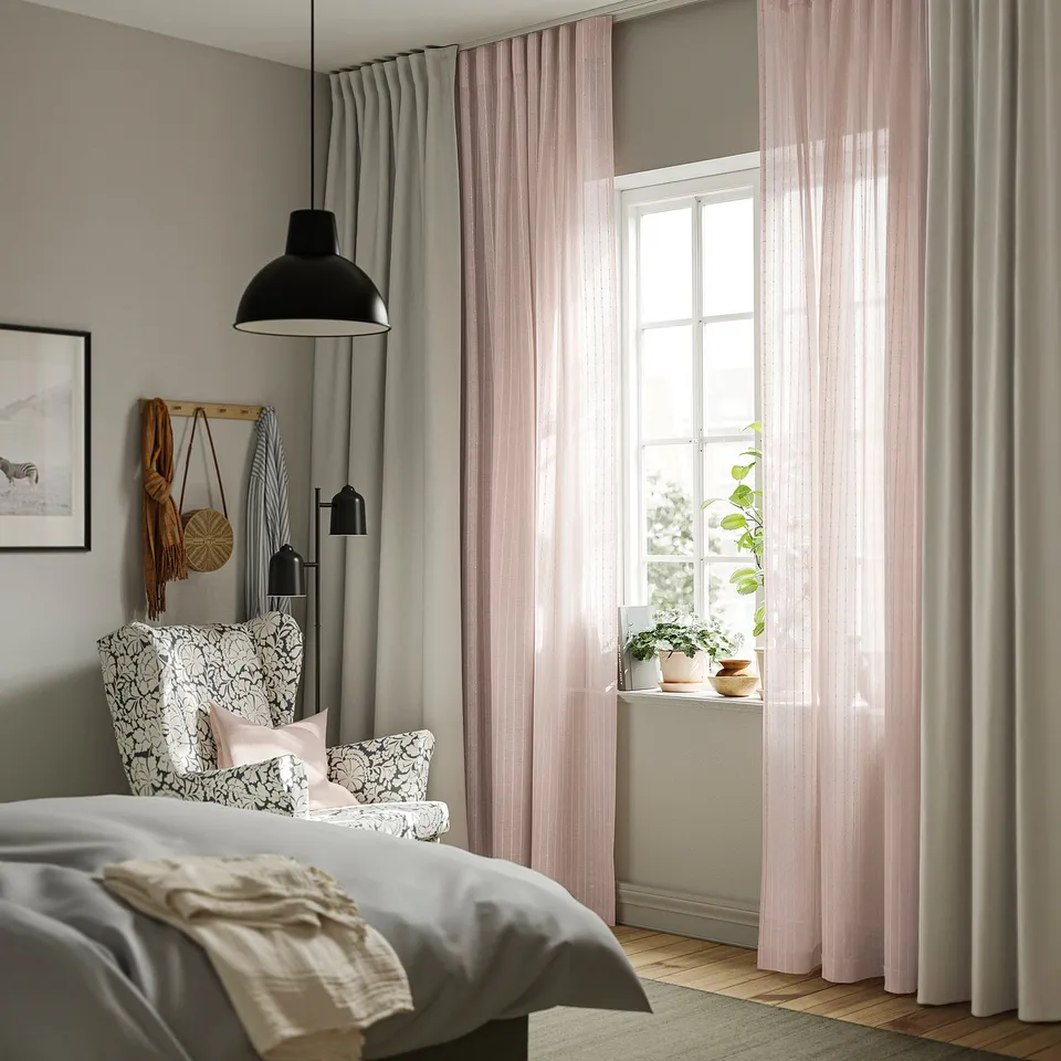 Pink sheer curtains in bedroom, eco-friendly, with stripes, lamp, grey walls, patterned bed.