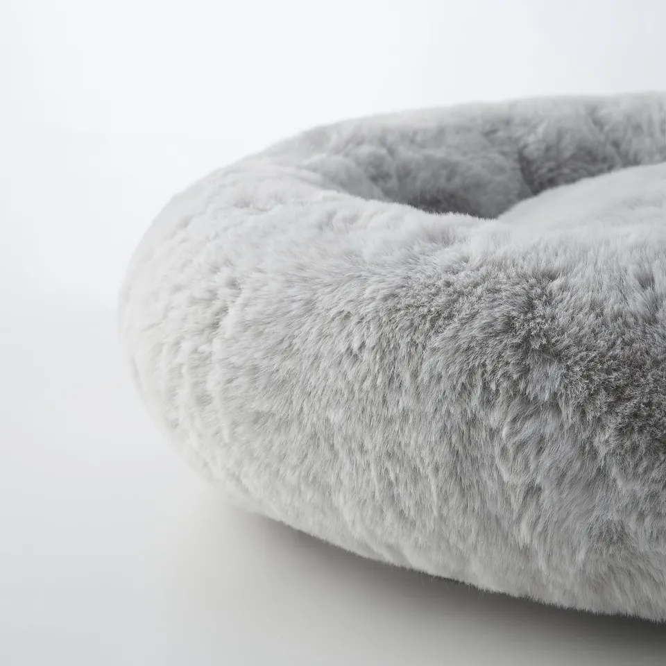 Cosy, plush, circular pet bed in soft faux fur, ideal for pets to relax and feel secure.