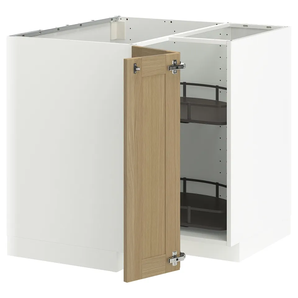 A white METOD kitchen cabinet with a light oak door slightly open, revealing black shelves inside.
