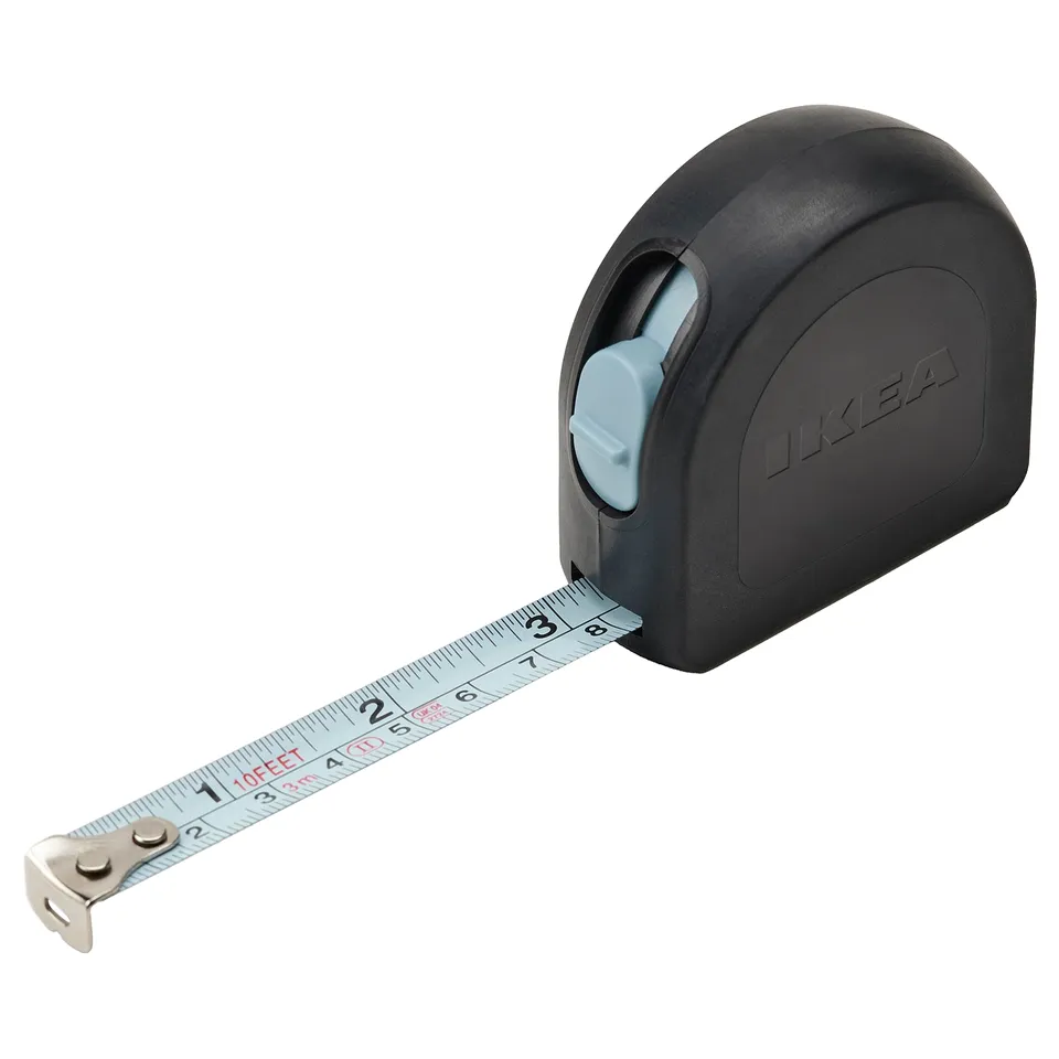 IKEA TRIXIG tape measure, black with grey button, rubberized body, steel measuring tape, precise markings, compact design.