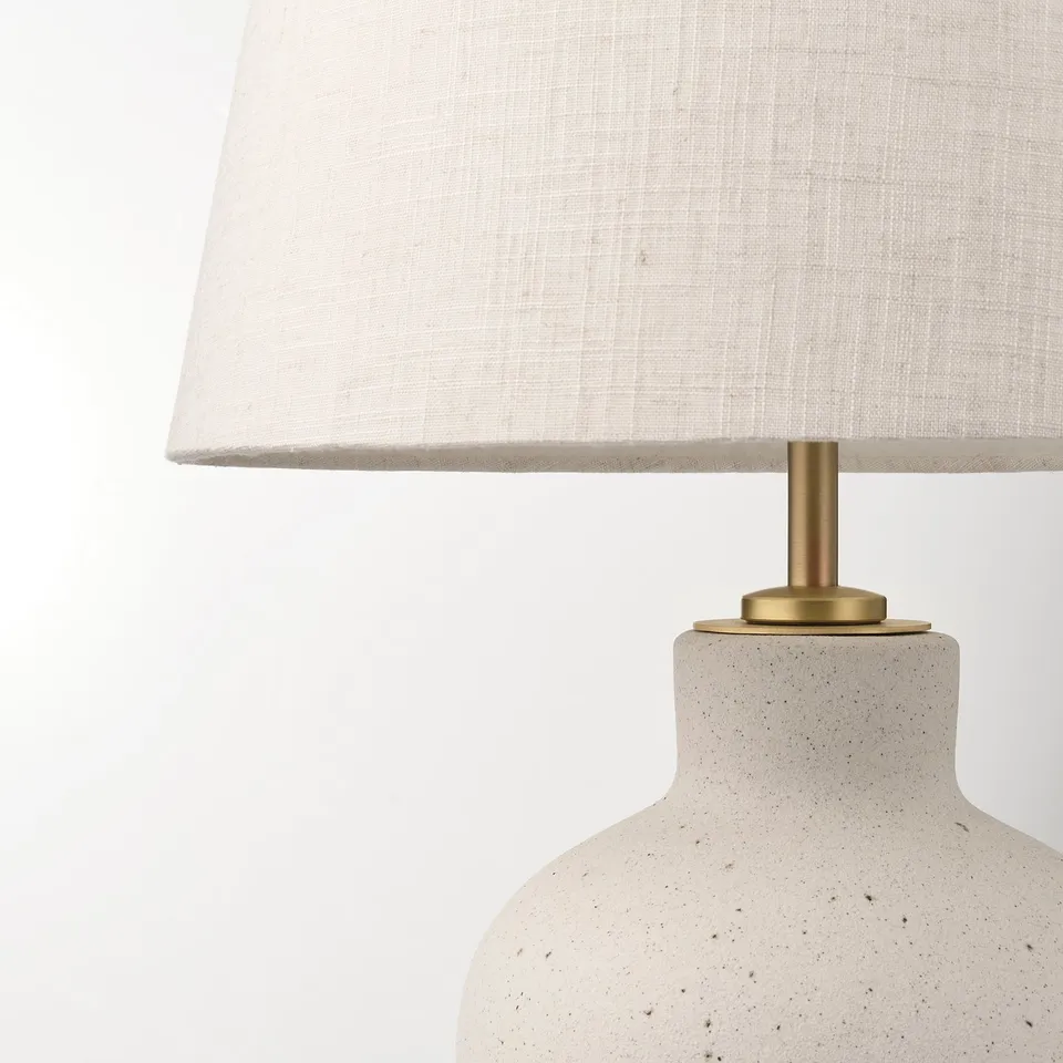 Modern lamp with speckled base and linen shade.