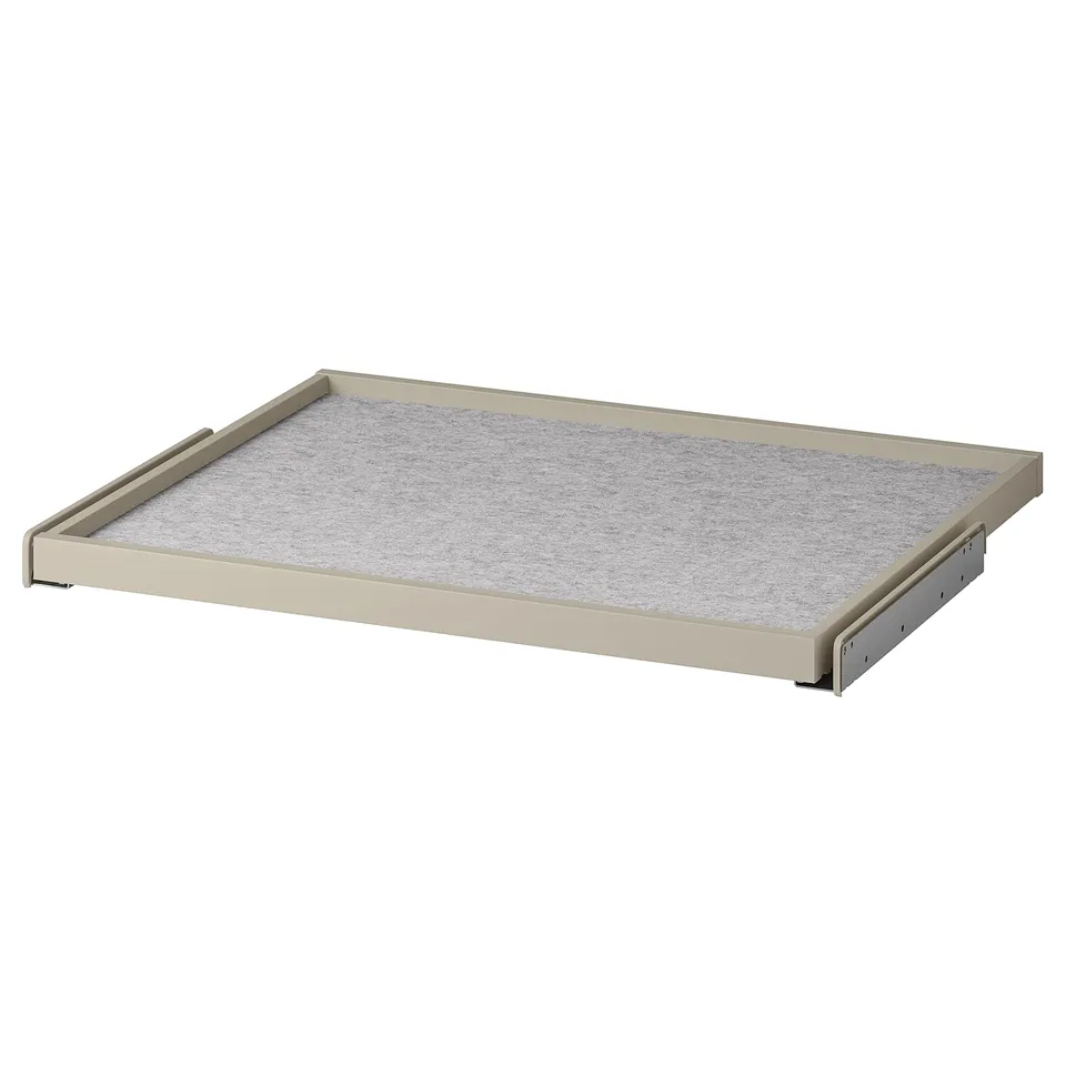 A beige KOMPLEMENT pull-out drawer tray with a grey felt mat, designed for wardrobe organisation.