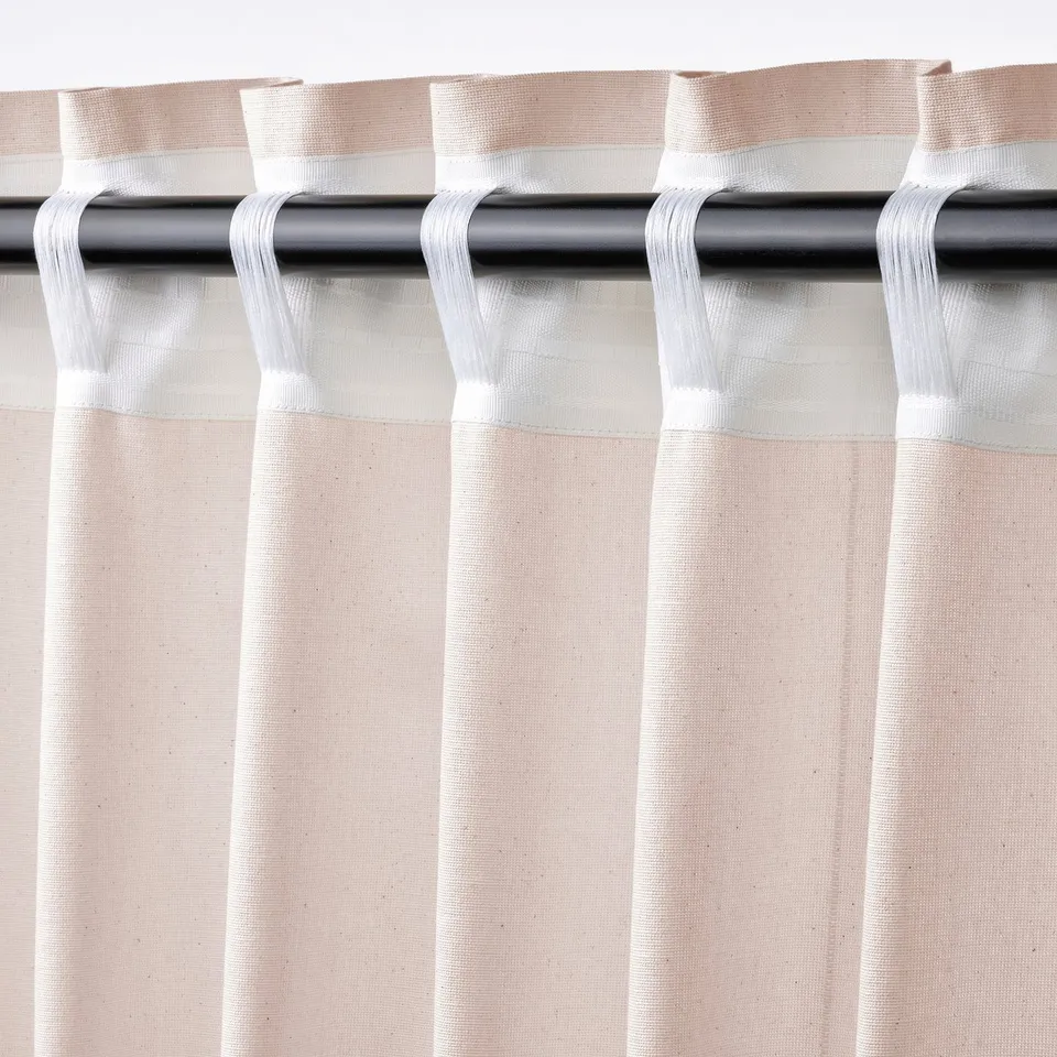 Curtain close-up: light pink with dark specks, rod pocket at top, tabs for hanging.