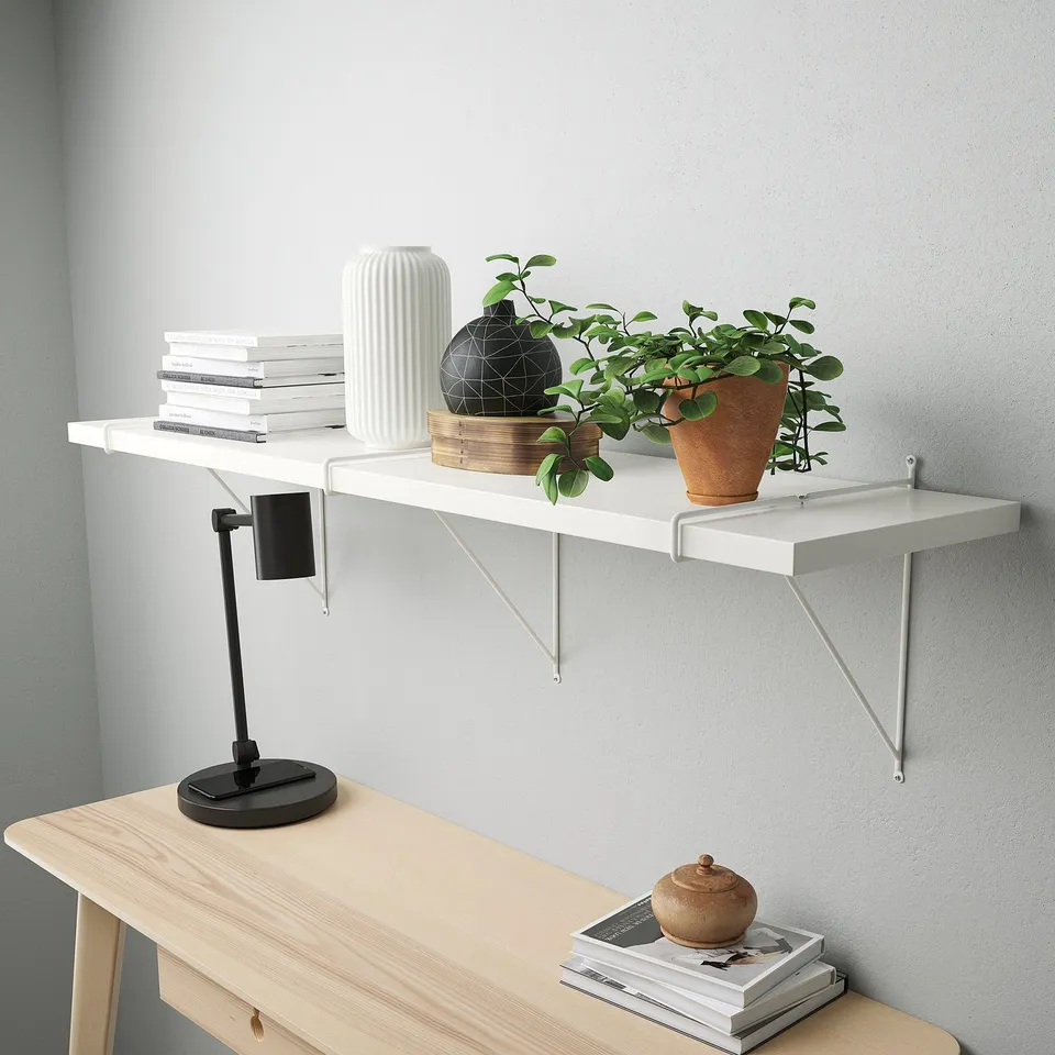 Modern wooden desk setup with shelf, books, vase, decor, plant, lamp and magazines.