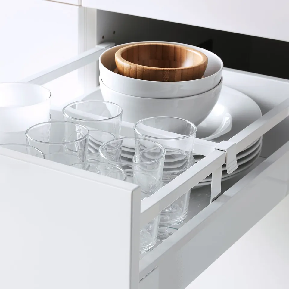 White kitchen drawer with clear glasses and bowls. Organised, self-closing drawers shown.