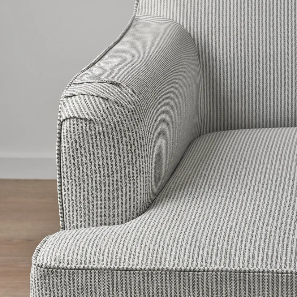 Striped upholstered chair with detailed piping, set in a clean room. Quality design with a 10-year guarantee.