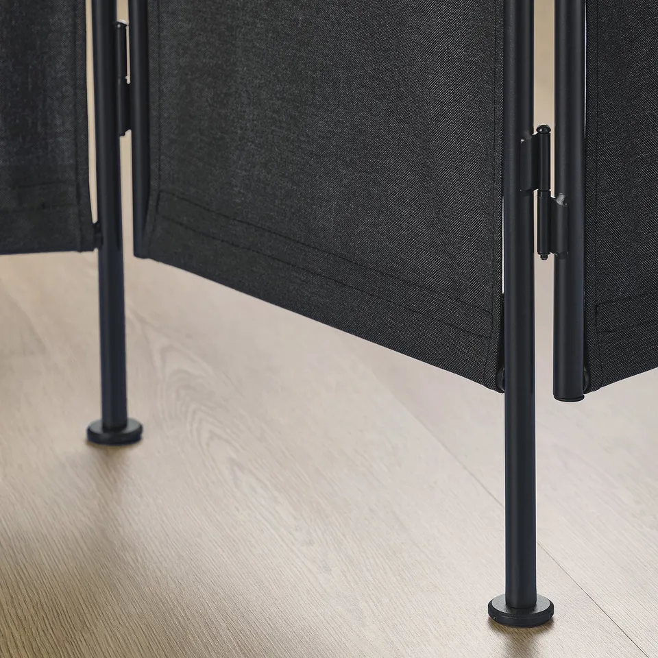 Room divider with black fabric and sturdy metal legs.
