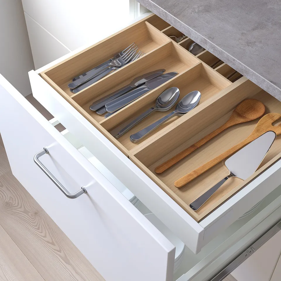 Pleated cutlery and wooden utensils in kitchen drawer organiser