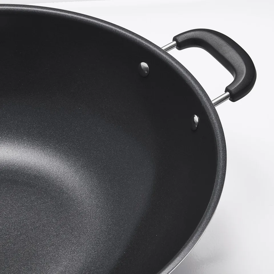 Black wok with two sturdy handles and a smooth non-stick interior, showcasing its high-quality construction.