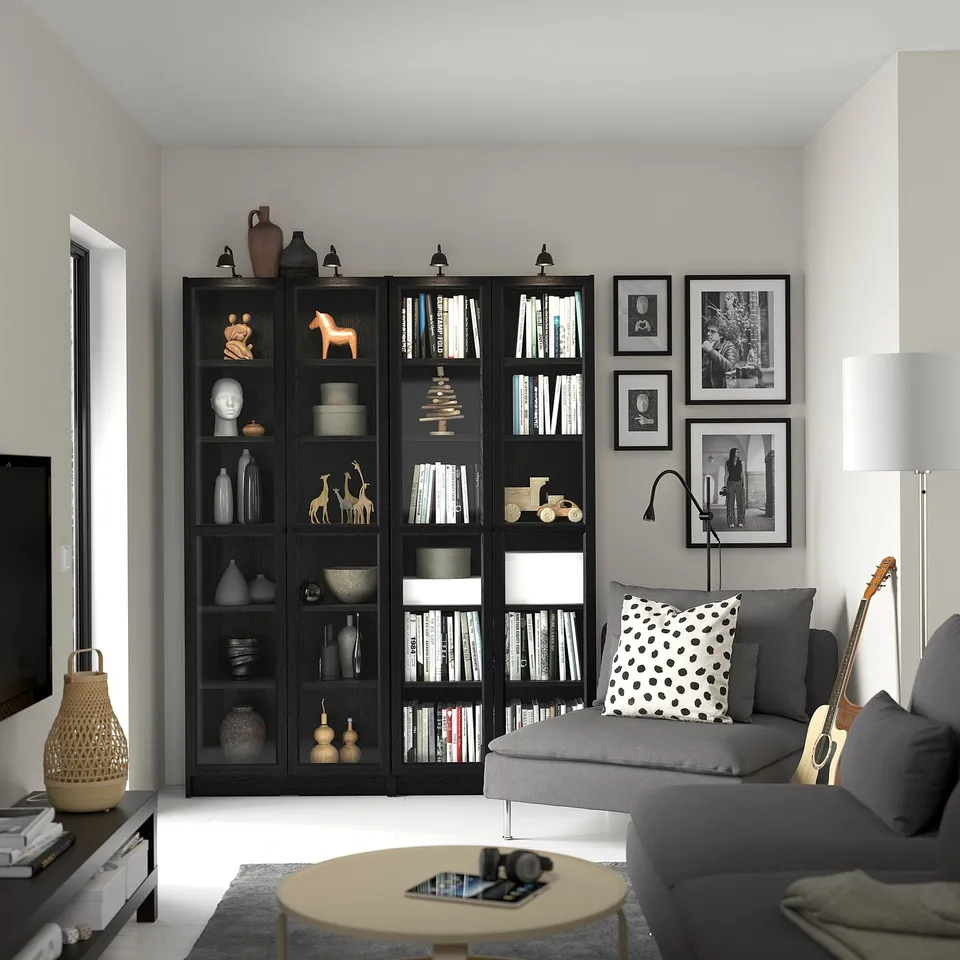 Modern living room with BILLY bookcase, couch, coffee table, guitar, lamp, and tv.
