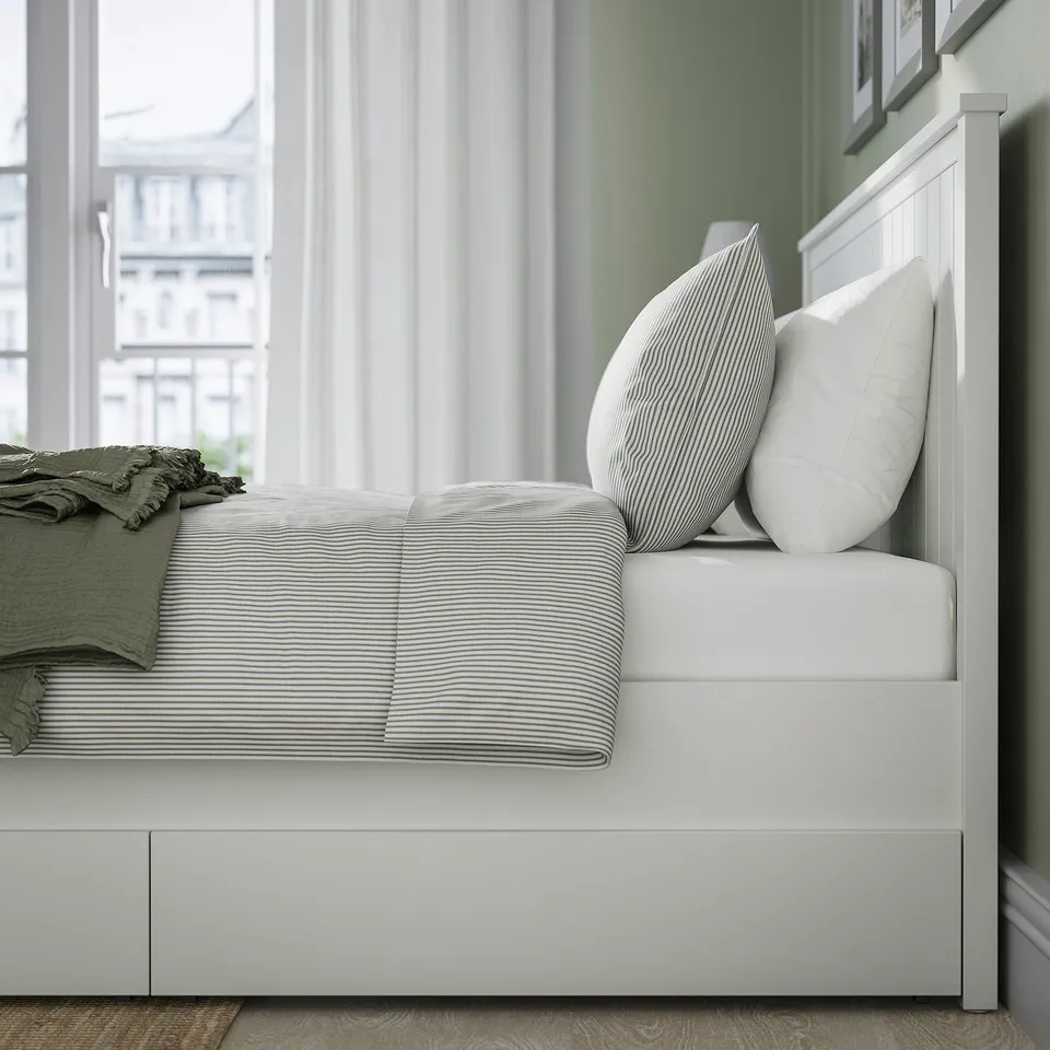 Neat bed with striped linens, two pillows, folded blanket, and white wooden headboard and shelf; part of the GULLABERG series.