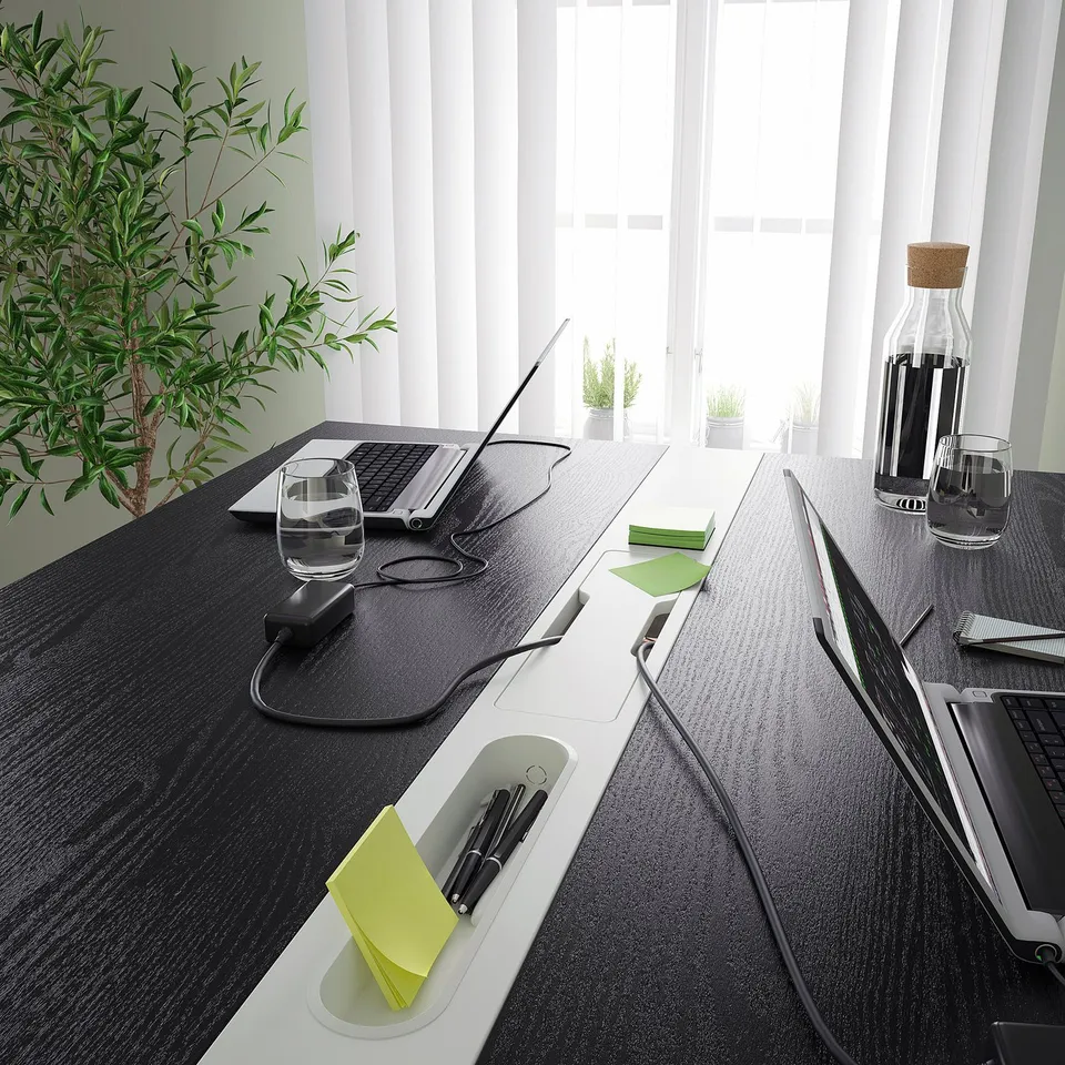 Conference table with standing/sitting options, featuring cable management, and a footrest for support. Ideal for meetings and work sessions.