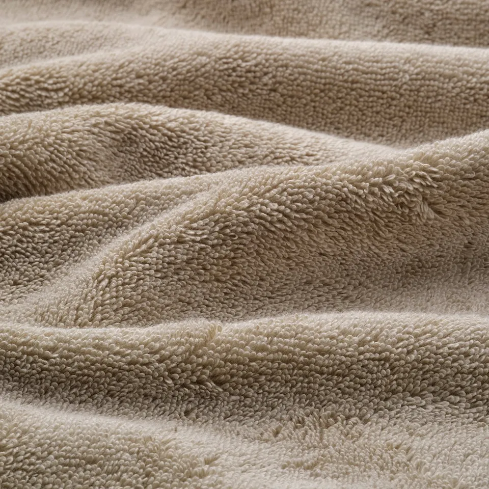 A thick, soft, organic cotton towel with a textured weave and elegant border, showcasing its quality and absorbency.