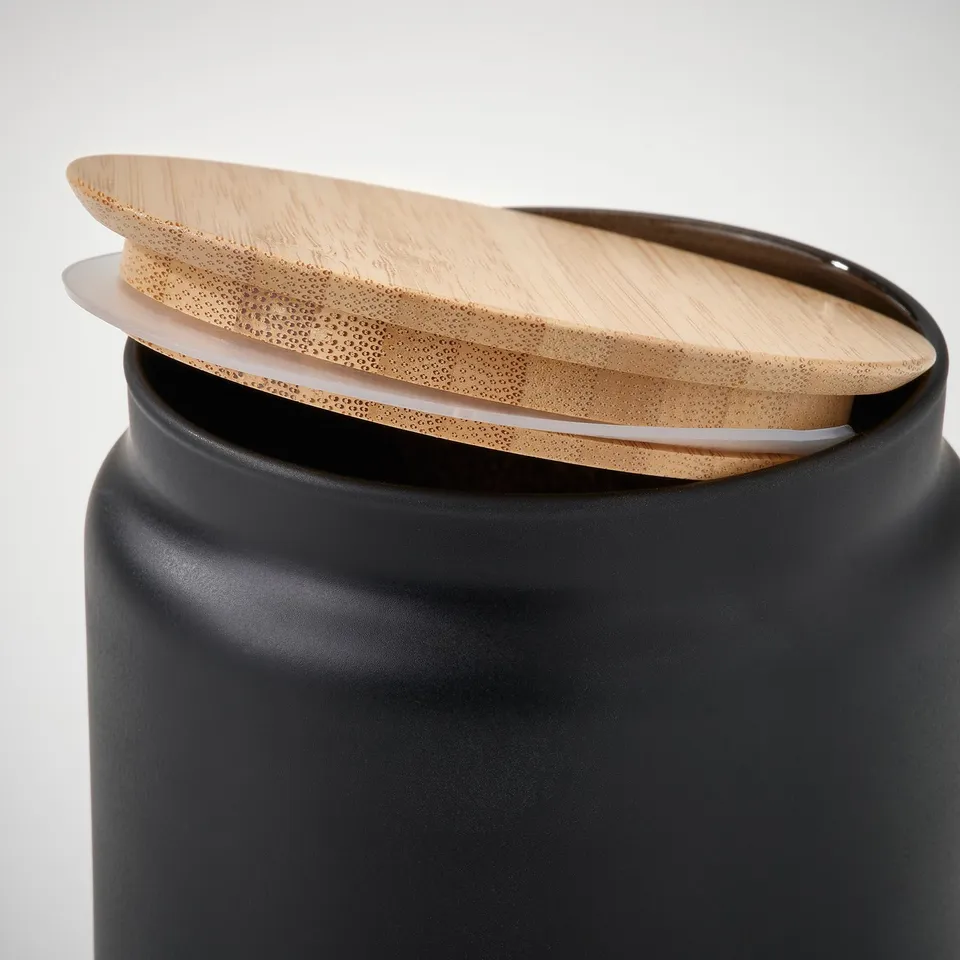 Black jar with wooden lid, tilted
