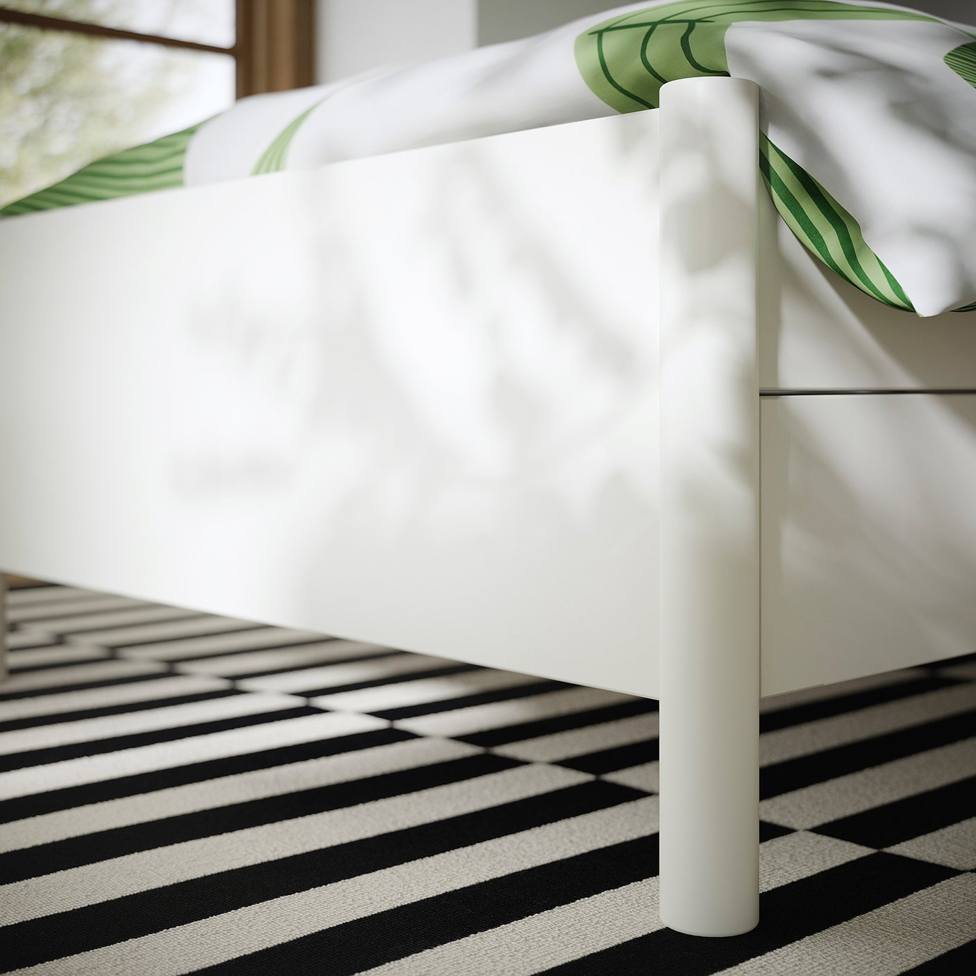 Close-up of TONSTAD bed frames sturdy, smooth white leg and drawer, showing quality finish and design.
