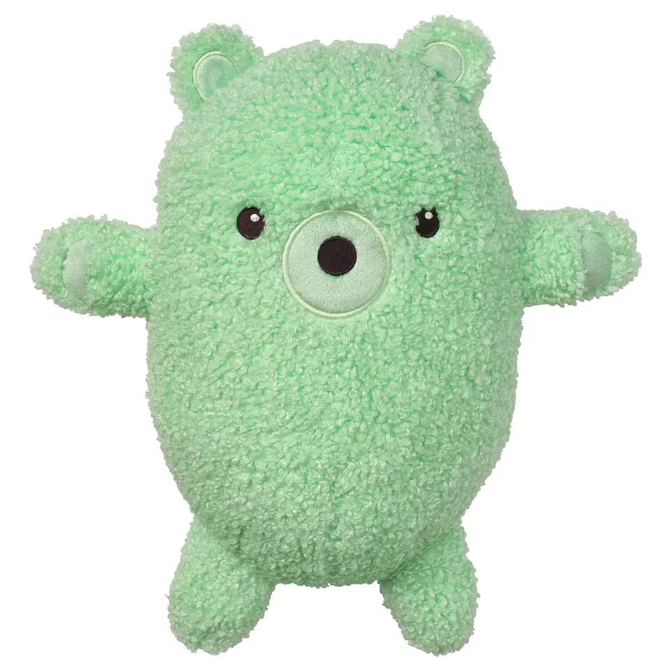 Green stuffed animal, bear-shaped, soft fabric, friendly face, arms outstretched.