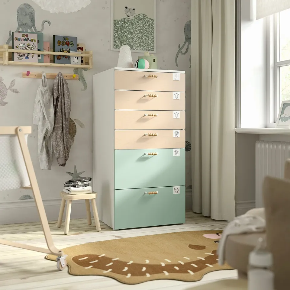 Childs room with SMÅSTAD drawers, bookshelf, stool, and dinosaur rug.