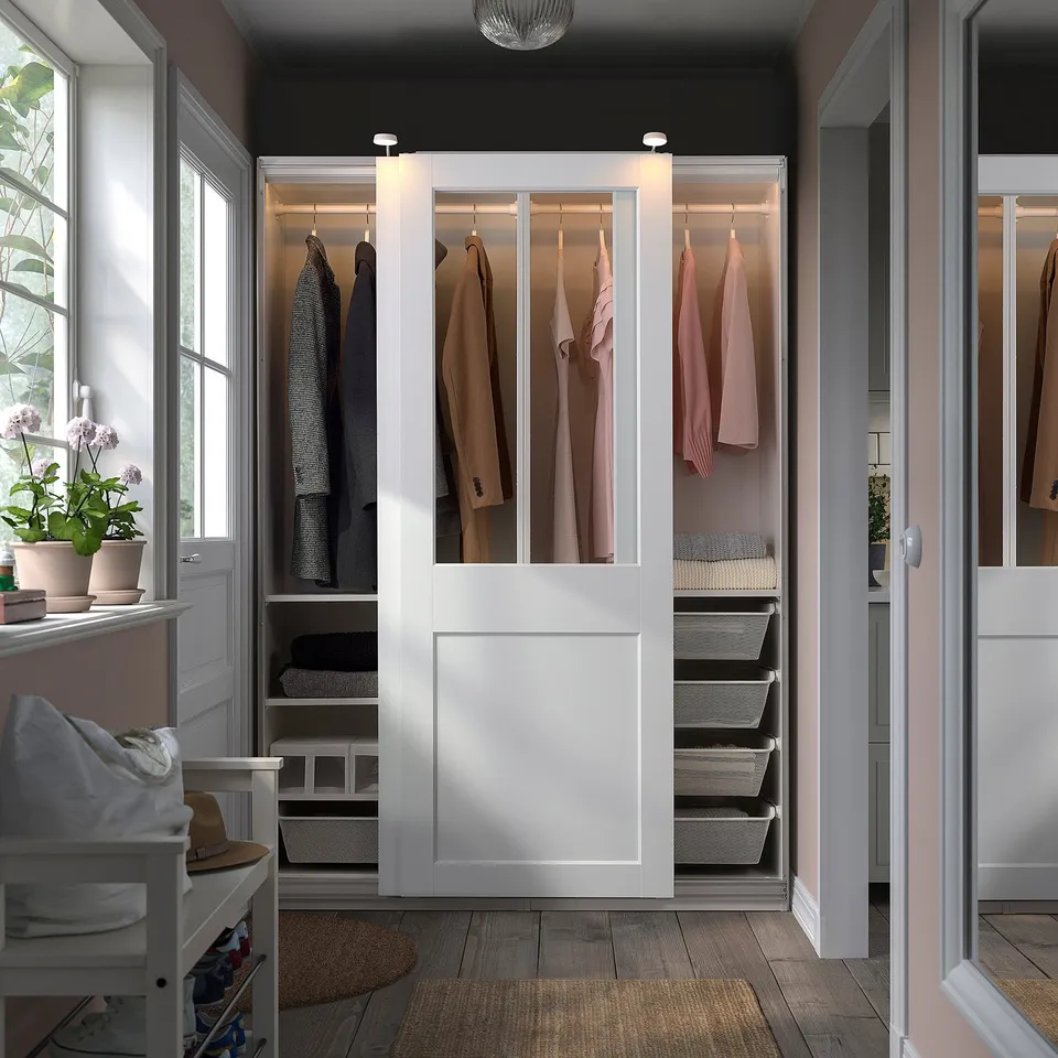 PAX wardrobe with glass doors, housing organised clothes, hats, and efficient storage.