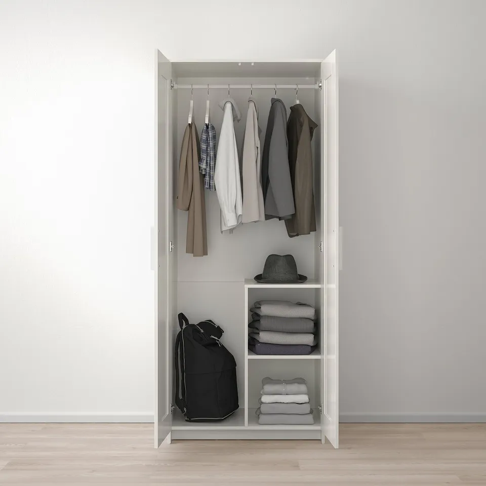 Open wardrobe with hanging jackets, folded clothes, and a backpack.