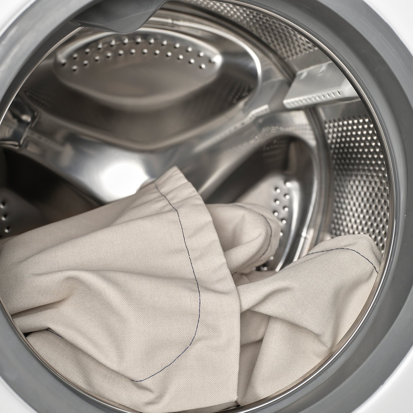 Washing machine drum with pants inside, illustrating machine-washable feature.