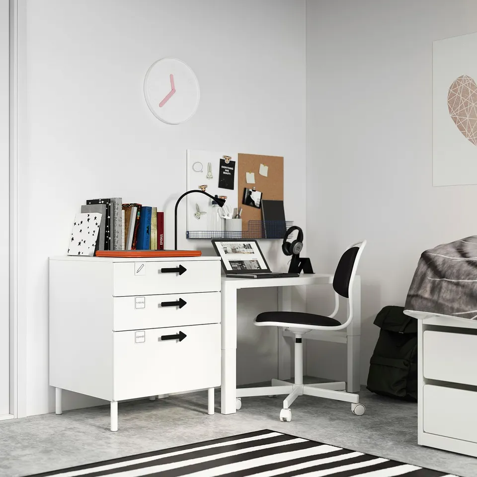 Teen bedroom with white & black furniture: SMÅSTAD desk, storage, chair & backpack. Grey walls & striped rug.