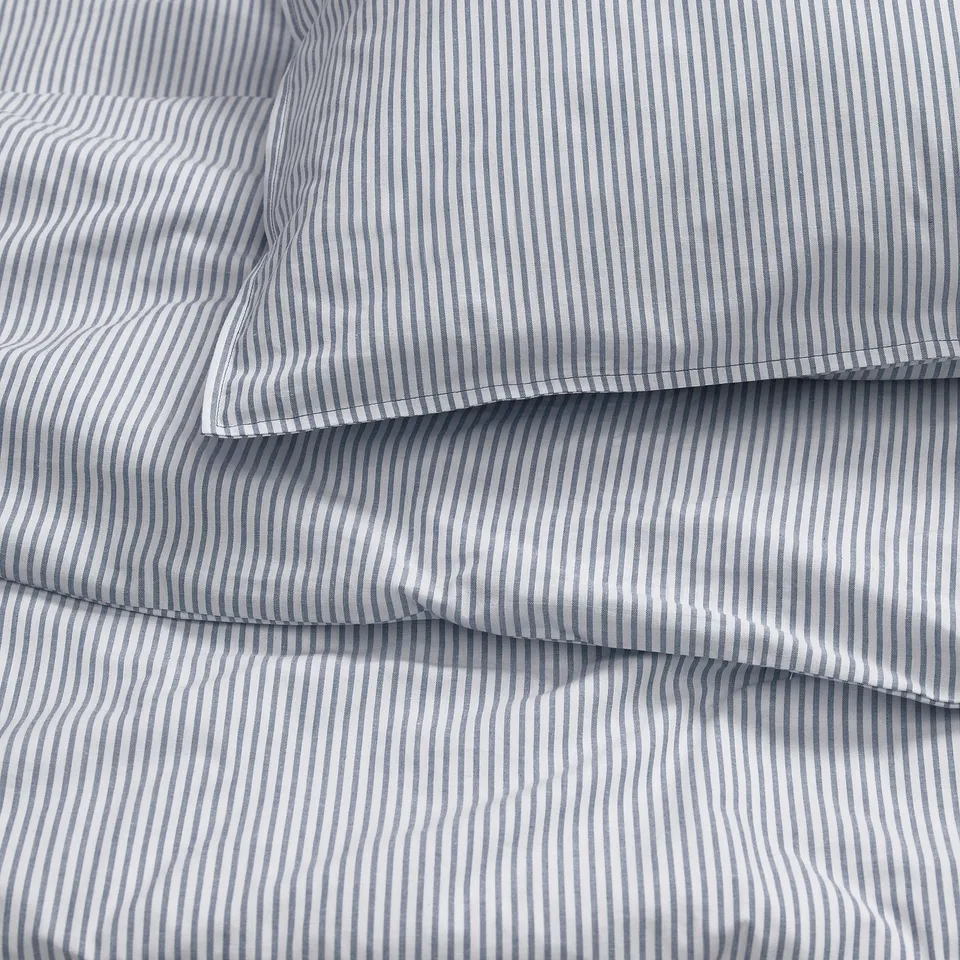 Grey striped bedding set made of 100% recycled cotton, neatly folded, showcasing soft stitching and quality material.