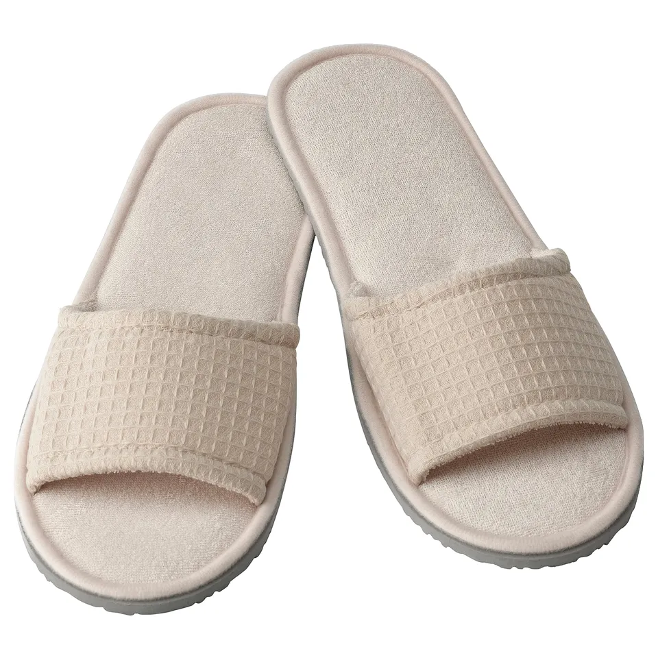 Light beige slippers with waffle texture, open-toe design, made from recycled polyester and eva foam, comfortable and cushioned.
