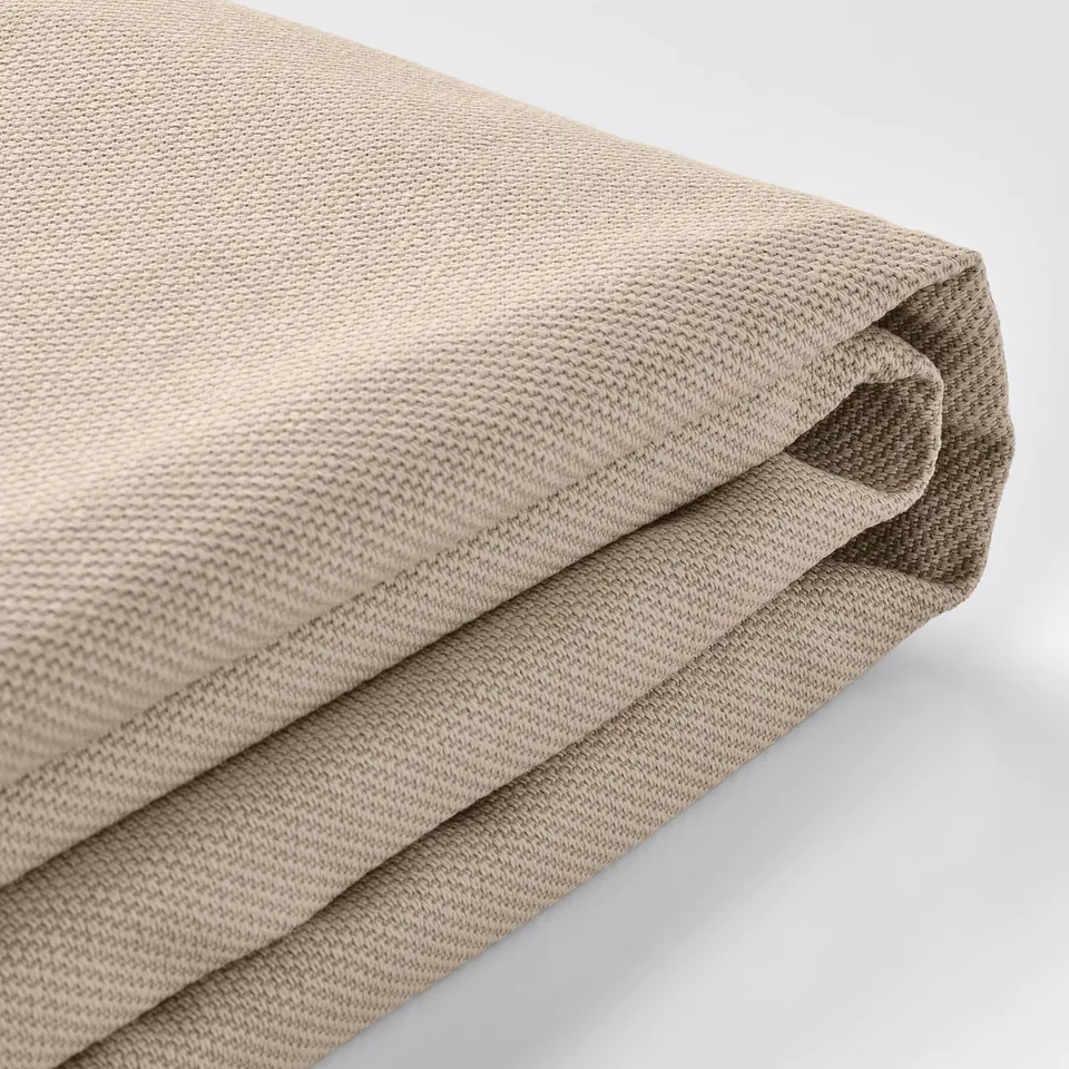 Neutral-toned, soft, textured upholstery fabric; slightly wrinkled and folded, showing durability and comfort.