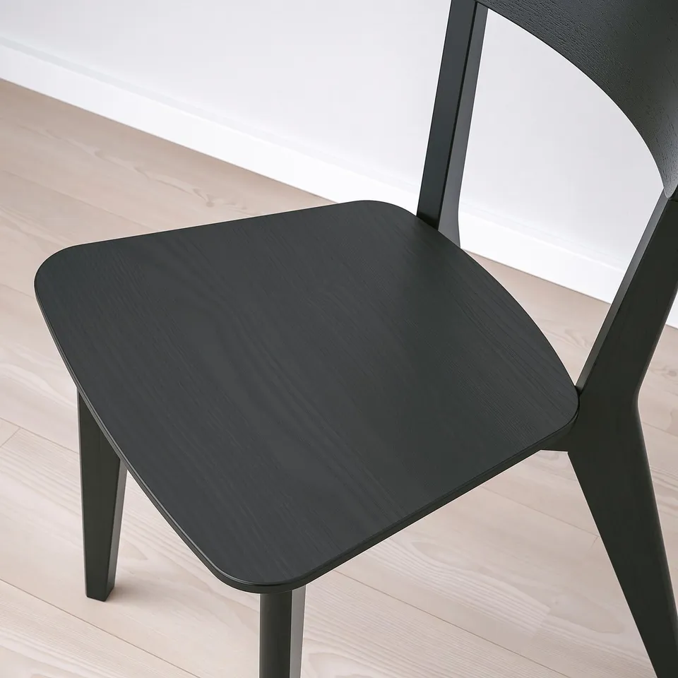 Black LISABO chair with ash veneer seat and solid birch legs. Modern and sturdy design on wooden floor.