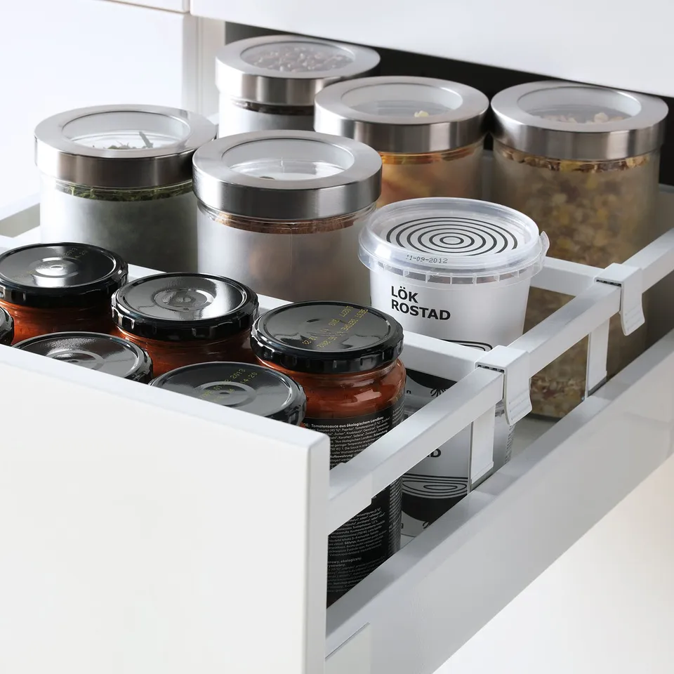 Open kitchen drawer showcasing organised containers and jars, featuring slow-close mechanism.